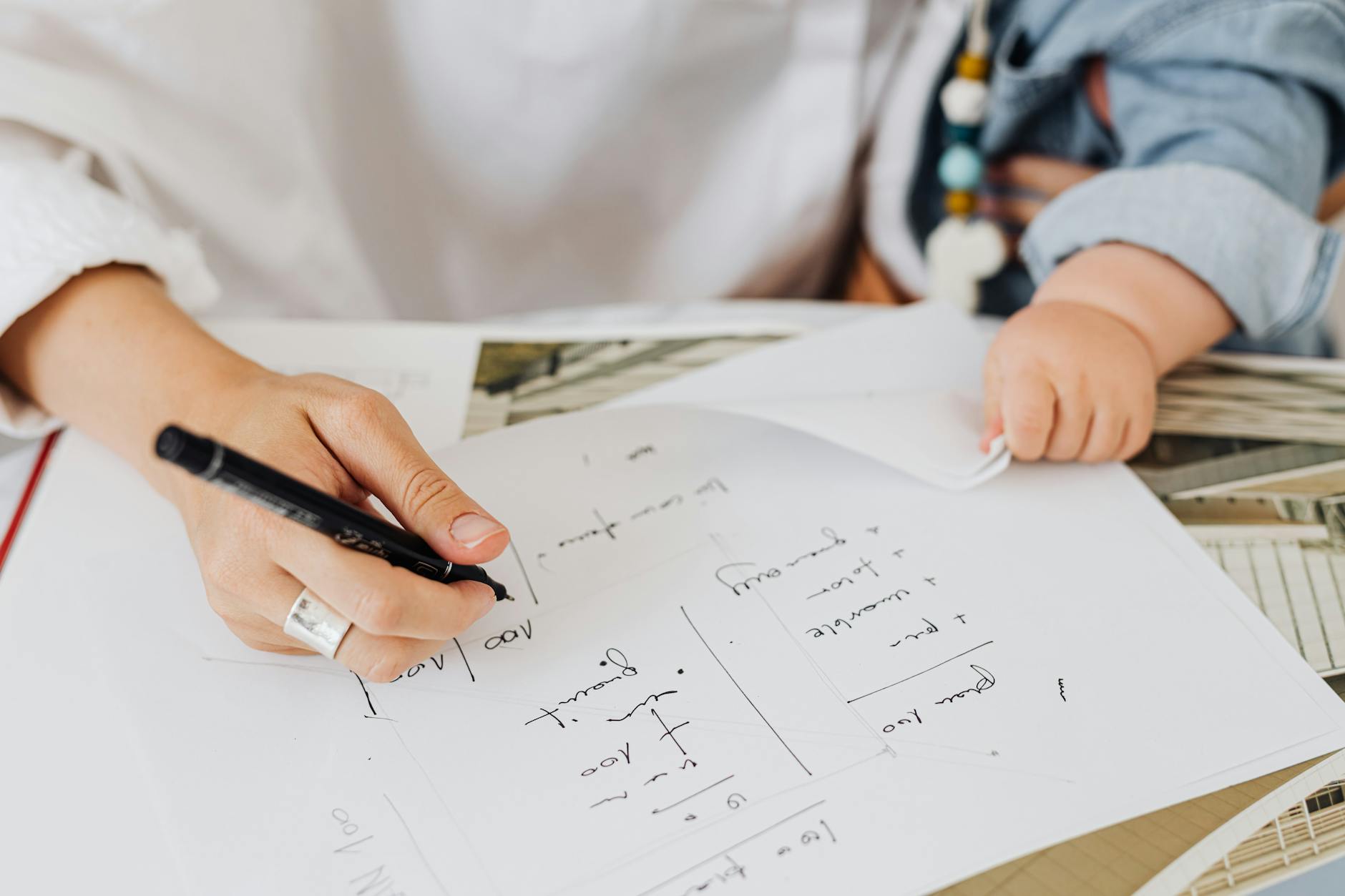 a person writing on white paper